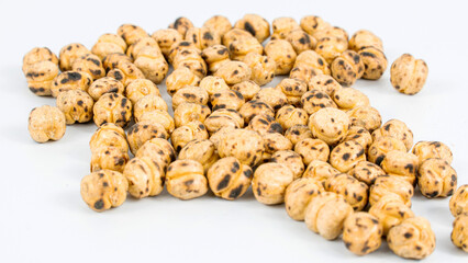 Fototapeta premium Roasted chickpea. Group of roasted chickpeas isolated on white background. selective focus. Leblebi in Turkish.