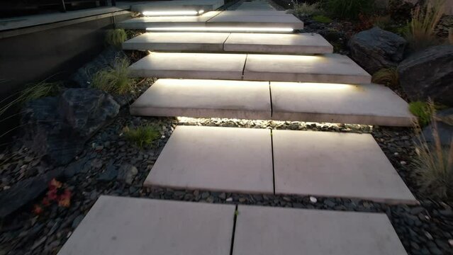 Modern Residential Backyard Garden with Elegant Large Illuminated Concrete Stairs. Rockery Garden Design.