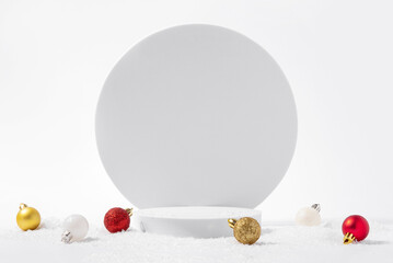 Cosmetic background for Christmas and winter holiday. White podium, christmas balls and snow on white background.