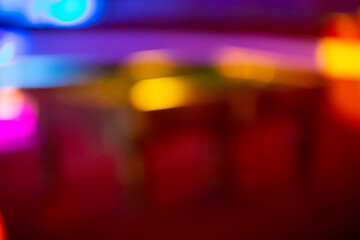 Blurred multicolored background with spots of yellow and purple bokeh. Red background with stripes similar to a night city.