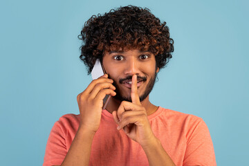 Fototapeta na wymiar Closeup of happy indian guy having phone conversation and gesturing