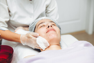 A cosmetologist cleanses the skin of a beauty salon client before the procedure and facial massage. The concept of beauty and health. cosmetology.