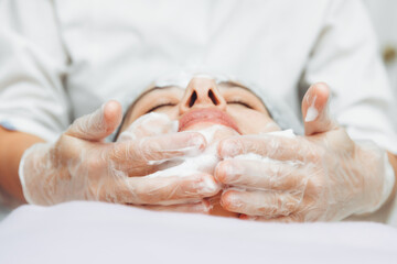 the cosmetologist cleanses the skin with foam. A woman's skin care procedure. Natural cosmetics. A...