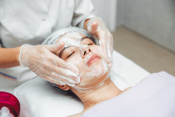 the cosmetologist cleanses the skin with foam. A woman's skin care procedure. Natural cosmetics. A...