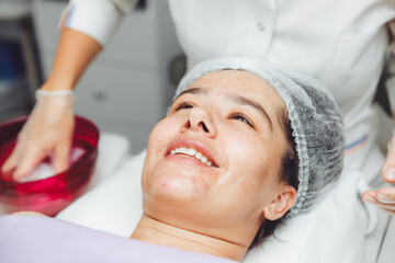 Obraz premium A cosmetologist cleanses the skin of a beauty salon client before the procedure and facial massage. The concept of beauty and health. cosmetology. pimple-covered skin