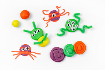 Funny monsters  made from plasticine for the holiday of Halloween on white background. Sensory play...