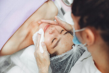 A cosmetologist cleanses the skin of a beauty salon client before the procedure and facial massage. The concept of beauty and health. cosmetology. pimple-covered skin