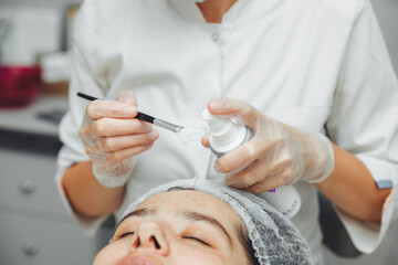 A cosmetologist does facial care and apply a face mask. cleansing a heavily soiled face. acne on the skin. skin rashes. mechanical face painting.