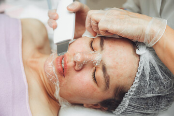 Ultrasonic cosmetic scrubber. Facial cavitation procedure. Salon skin care procedure. Professional...