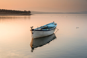 Fishers boats on the lake, calm water with beautiful reflection of colorful sky tranquily scene
