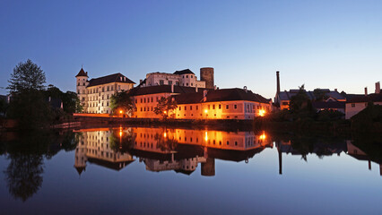 Jindrichuv Hradec Castle and Chateau, beautiful landmark mirroring in pond during night after sunset, popular tourist destination Jindrichuv Hradec, Czechia