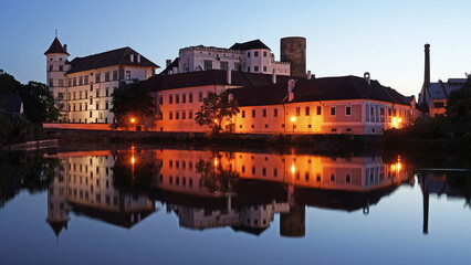 Jindrichuv Hradec Castle and Chateau, beautiful landmark mirroring in pond during night after sunset, popular tourist destination Jindrichuv Hradec, Czechia