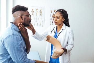Obraz premium Young man with injury of neck visiting doctor in clinic. Doctor examining a patient at desk in medical office. Doctor talking to a male patient with cervical collar at the hospital