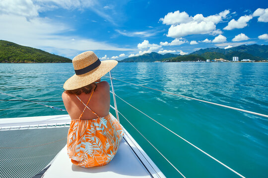 Young Elegant Woman Sitting On Yacht Enjoy View Sea And Coast City Nha Trang During Sailing Trip. Holiday On Vietnam.