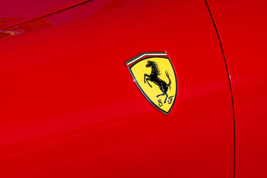 BAYONNE, FRANCE - CIRCA AUGUST 2022: Closeup shot of Ferrari logo featuring the Prancing Horse on a red car.