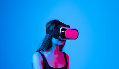 Metaverse technology concept. Woman with VR virtual reality goggles is working in the studio....