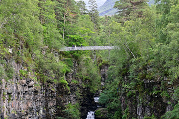 Suspension bridge over the gorge at the Falls Of Measach waterfall near Braemore, Highland, Scotland