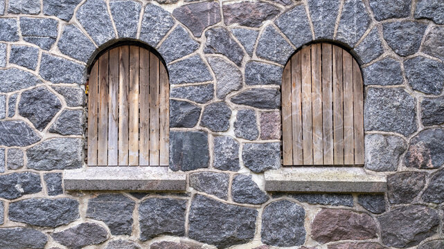 Old, boarded up window in the ruined wall of an old manor house in Latvia