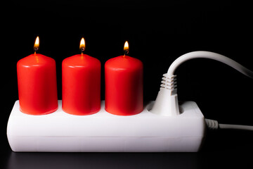 Energy price increase. Burning candles in an electrical extension cord. Increase in energy bill prices.