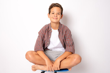 Boy sitting on a chair isolated on white background.