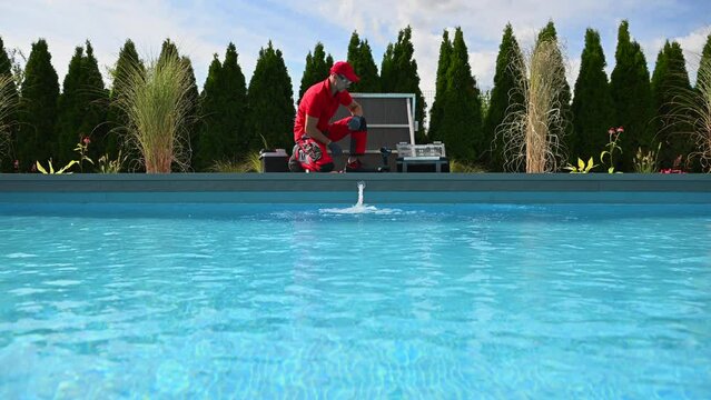 Professional Caucasian Swimming Pools Technician in His 40s Performing Seasonal Maintenance. Outdoor Residential Backyard Pool.