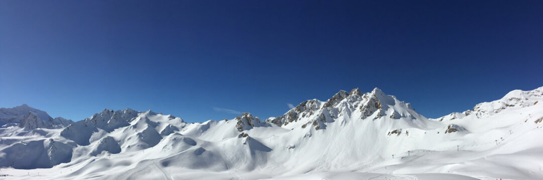 Panorama of snowy mountain peaks and ski slopes at Tignes, ski resort in the Alps, France