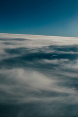 Obraz premium View over the clouds. Cloud cover seen from an airplane. Beautiful sunset sky above clouds. Beautiful orange and pink sunrise over the clouds