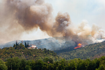 Fototapeta premium Helicopter against wildfire during strong wind and drought near Miren Castle in Slovenia