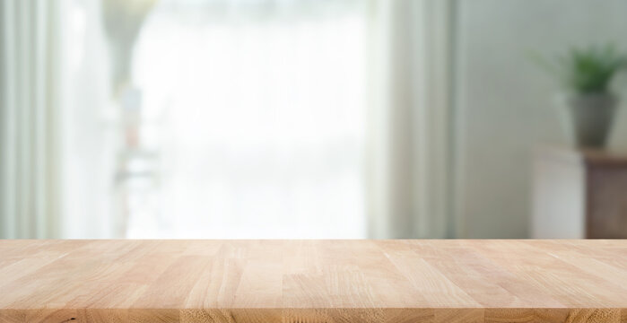 Empty wood table top on blur abstract home room,window view.