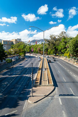 Fototapeta na wymiar Car traffic on an important avenue in the city of Belo Horizonte. In the background, buildings and Serra do Curral. Blue sky with clouds.