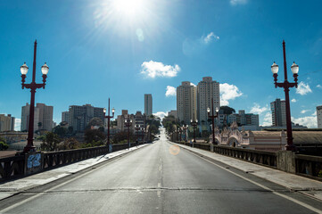 Fototapeta na wymiar Sun in blue sky with few clouds at Santa Tereza viaduct in the city of Belo Horizonte. Old lampposts.