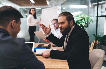 Focused colleagues discussing project on meeting