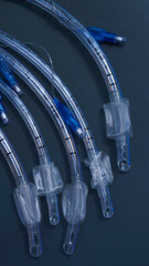 endotracheal tubes of different diameters lie on a dark background.  close-up