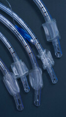 endotracheal tubes of different diameters lie on a dark background.  close-up