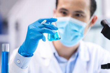 blue chemical liquid experiment in scientific glassware equipment in science medicine laboratory, chemistry or biology research discovery by using glass of test tube or beaker and flask