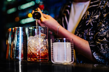 woman hand bartender making negroni cocktail in bar