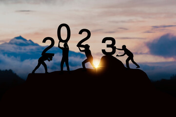 teamwork to success in 2023, silhouette of new year number on with team of worker help and put it up to top
