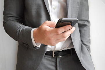 Midsection of businessman holding a mobile phone