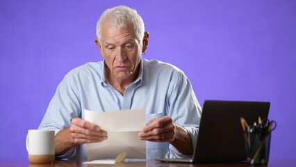 Portrait of happy excited male elderly man opening mail letter reading good news celebrating success, receiving loan approval, salary bonus, get promoted concept isolated on solid purple background - Powered by Adobe