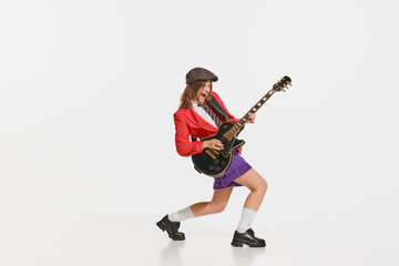 Stylish girl, retro musician wearing vintage style bright clothes playing guitar like rockstar...
