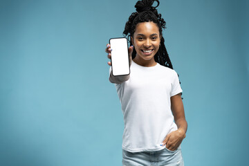 Portrait of excited and surprised young woman holding smartphone with white blank screen in hand,...