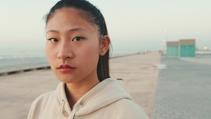 Fototapeta premium Close up of asian girl wearing sportswear looking at camera at morning time