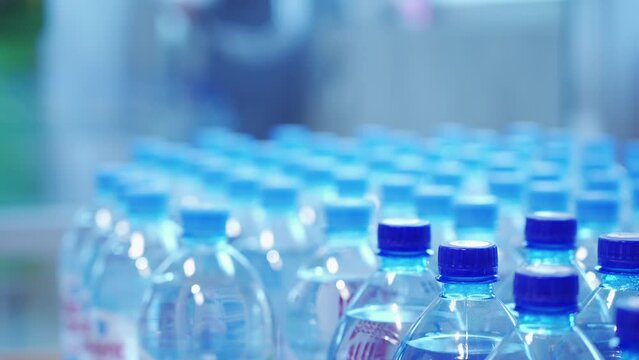A woman chooses bottled water in a grocery store
