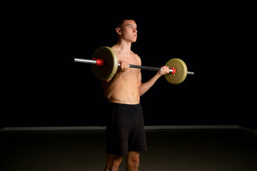 Obraz premium Nineteen year old teen boy exercising his biceps shirtless