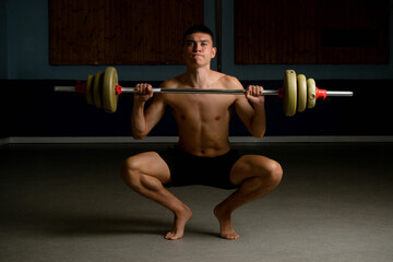 Fototapeta na wymiar Nineteen year old teen boy exercising with a barbell