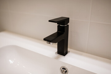 Black, metal tap for light bath