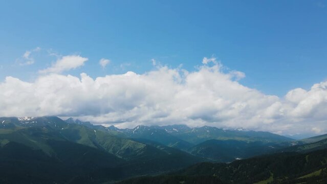 panorama of mountain peaks with clouds in summer in teberda shot on a drone