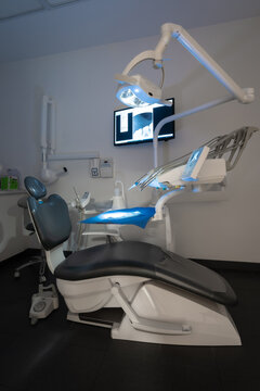 Modern dental practice. Dental chair, medical light, dental clinic without people. Vertical photo without light