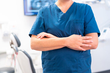 Dental clinic, unrecognizable caucasian female dentist with arms crossed