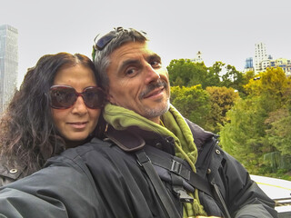 Happy couple taking selfies in the city park, foliage season